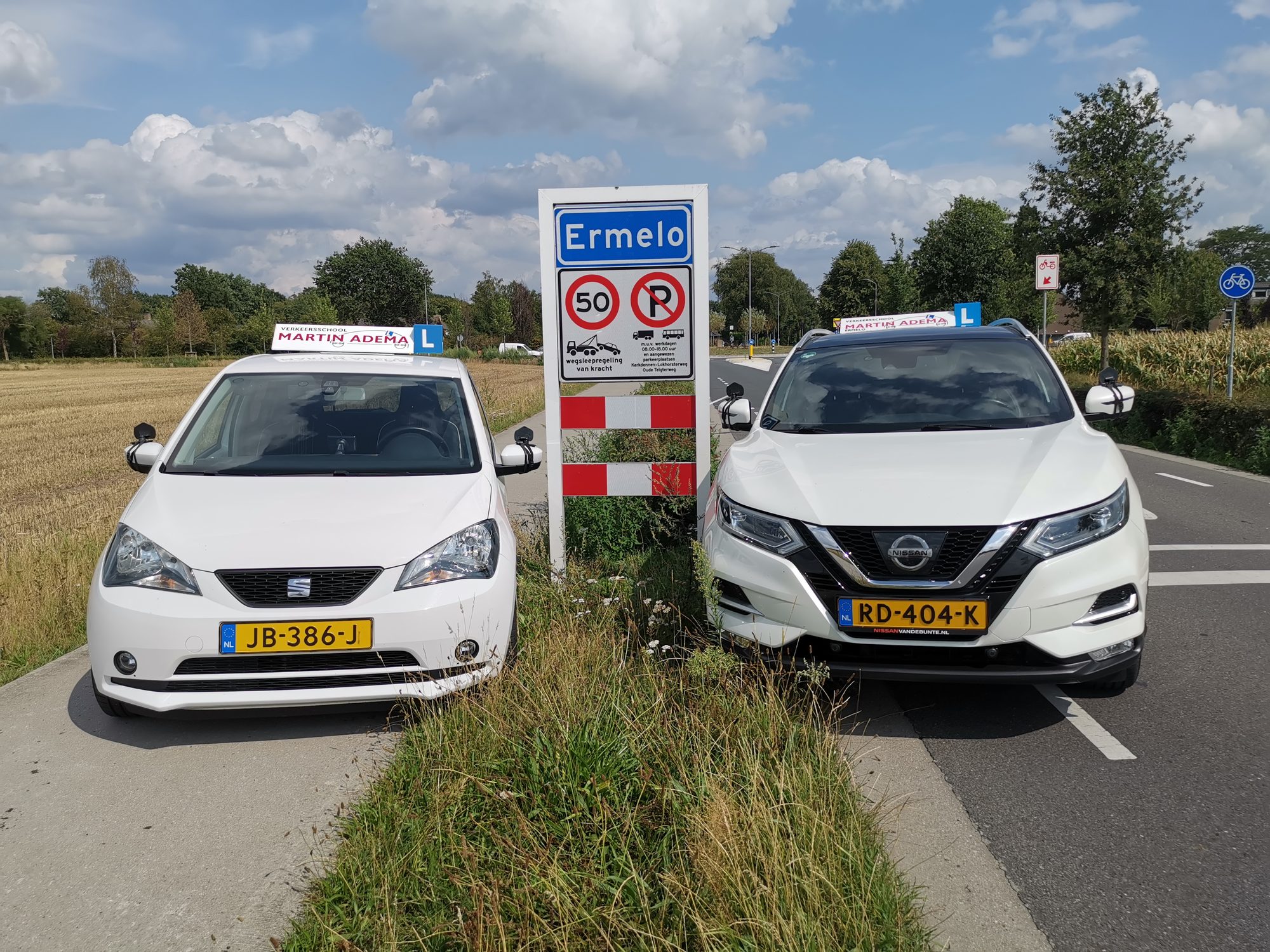 De lesauto's van Verkeersschool Martin Adema bij het plaatsnaambord Ermelo